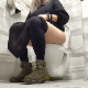 A woman who is only shown from the hips down and wearing a long skirt takes a shit while sitting on a wall-mounted toilet. Presented in 720P HD. About 5.5 minutes.